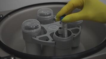 Test tubes are getting inserted into a biochemical analyzer by a lab worker video