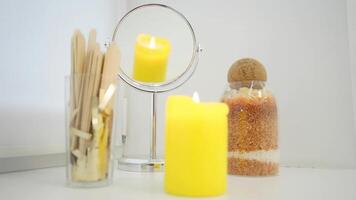 Lighted wax candle is reflected in the mirror and demonstrates the comfort in the beauty parlor, sticks for analysis video