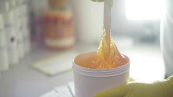 Depilation master woman scoop up the sugar paste right before the procedure of epilation video