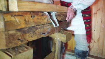 The ancient Quern stone hand mill with grain. The man grinds the grain into flour with the help of a millstone. Men hands on a millstone. Old grinding stones turned by hands video