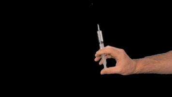 Alpha channel. Male hands presenting a syringe in their hands fill it with medicine or a vaccine taking it from a glass flask for use in the treatment of diseases video