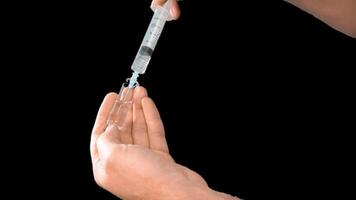 Alpha channel. Male hands presenting a syringe in their hands fill it with medicine or a vaccine taking it from a glass flask for use in the treatment of diseases video