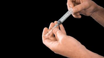 Alpha channel. Male hands presenting a syringe in their hands fill it with medicine or a vaccine taking it from a glass flask for use in the treatment of diseases video