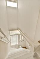 A white stairway with a window and a door photo