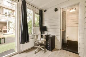 A small office with a desk, chair and window photo