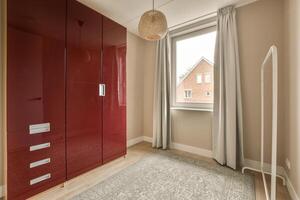 A room with a red cabinet and a window photo