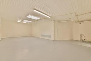 An empty room with a white ceiling and a light photo