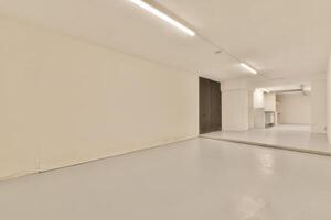 An empty room with white walls and a white floor photo