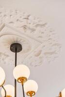 A ceiling with four chandeliers and a decorative design photo
