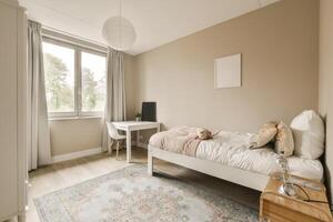 A bedroom with a bed, desk and window photo