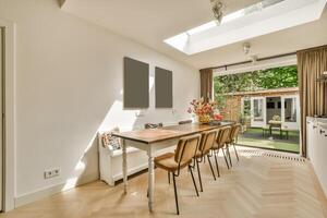 A kitchen with a table and chairs in front of a skylight photo