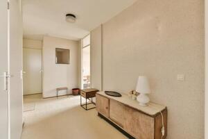 A hallway with a table and a lamp in it photo