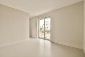 Empty room with white walls and a large window photo