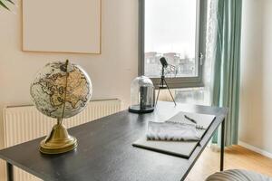 A desk with a globe, notebook and pen on it photo