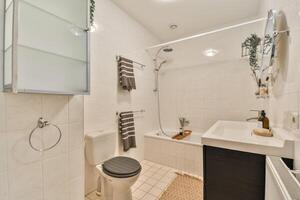 A bathroom with a toilet, sink, and shower photo