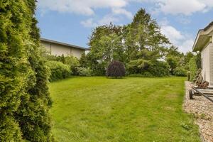 A yard with a lawn and trees in the background photo