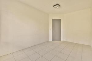 Empty room with tile floor and white walls photo