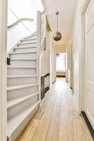 A hallway with a white door and a wooden floor photo