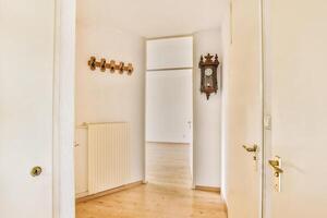 A hallway with a wooden floor and a clock photo
