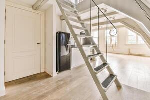 An open loft with stairs and a refrigerator photo