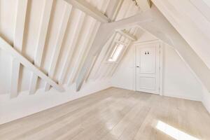 An empty attic with wooden floors and a door photo