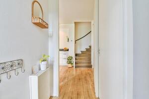 A hallway with a wooden floor and a white door photo
