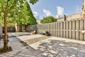 A patio with a tree and a fence photo