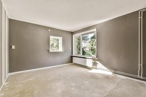 An empty room with gray walls and a window photo