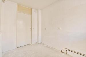 An empty room with a door and a white wall photo