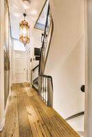 A hallway with a wooden floor and a staircase photo