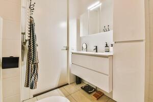 A bathroom with a white sink, toilet and mirror photo