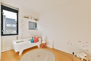 A small room with a white crib and a window photo
