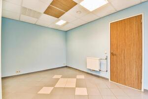 An empty room with a door and tile floor photo