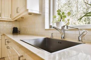 A kitchen sink with a window in the background photo