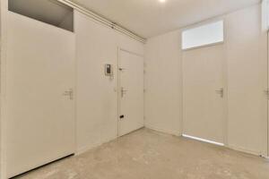 A white room with two doors and a window photo