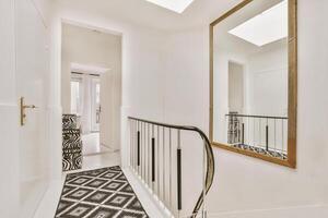 A hallway with a black and white rug and a mirror photo