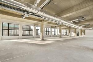 An empty office space with large windows and lots of light photo