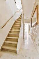 A hallway with a staircase and a mirror photo