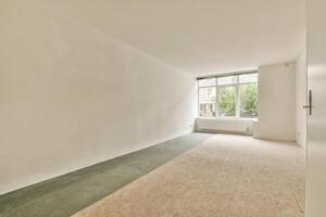 An empty room with a window and a green floor photo