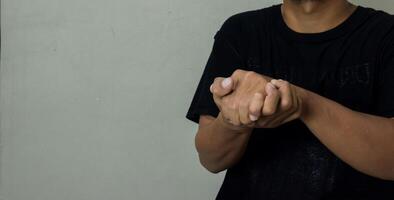 young man showing Believe gesture in sign language to communicate photo