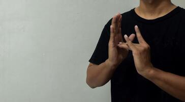 young man showing word jesus using sign language to communicate photo