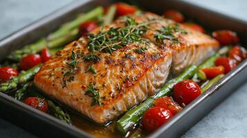 Grilled salmon fillet served with roasted cherry tomatoes and asparagus on a rustic wooden table photo