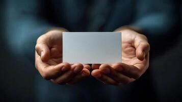 Person holding a blank business card in hands with a soft background during daylight photo