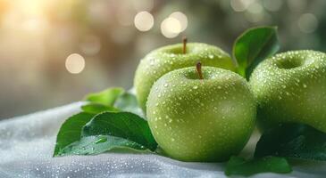 Freshly washed green apples resting on leaves with morning dew in a bright, natural setting photo