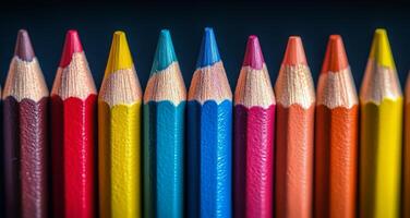 Colorful pencils arranged neatly on a dark surface for artistic creativity photo