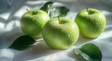 Freshly washed green apples resting on leaves with morning dew in a bright, natural setting photo