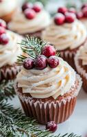 Festive cupcakes topped with cream frosting and cranberries on a winter day photo