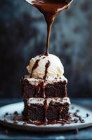 Delicious brownie stack topped with vanilla ice cream and drizzled chocolate sauce photo