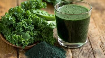 Fresh green smoothie served in a glass with kale and spirulina on a wooden table photo