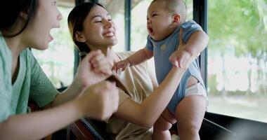 Footage of handheld shot, Two happy women having fun playing with a little boy in a coffee shop. Family enjoying time together. Happy lifestyle. video